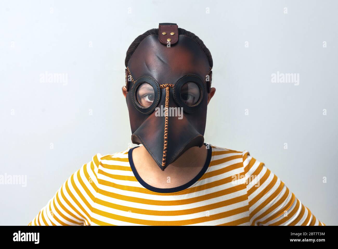 Girl in a mask of a plague doctor on a gray background. medical face shield. pandemic concept Stock Photo