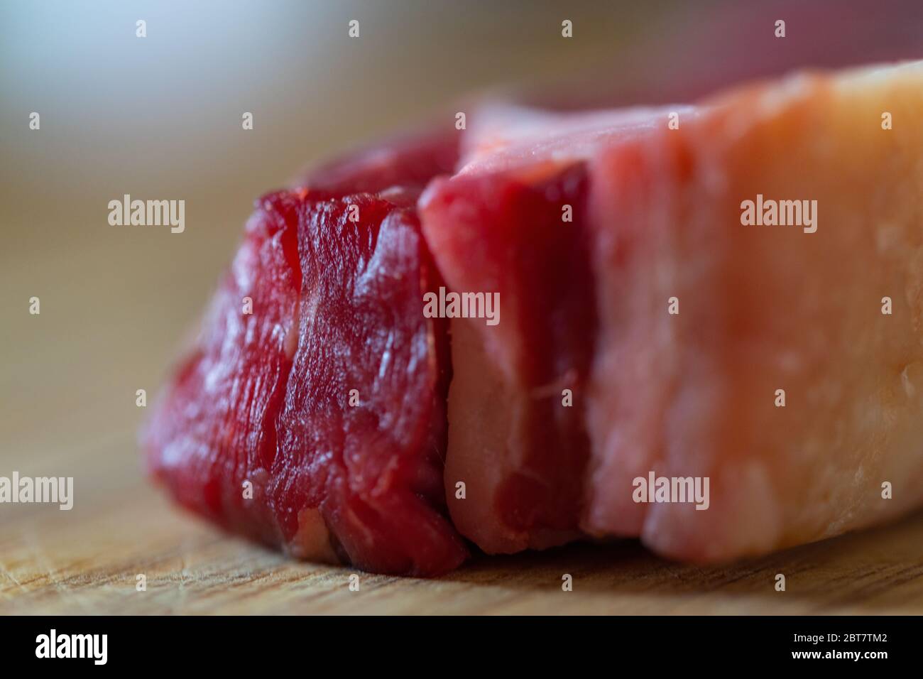 Shots of a sliced raw fresh rump steak with fat on the steak on a ...