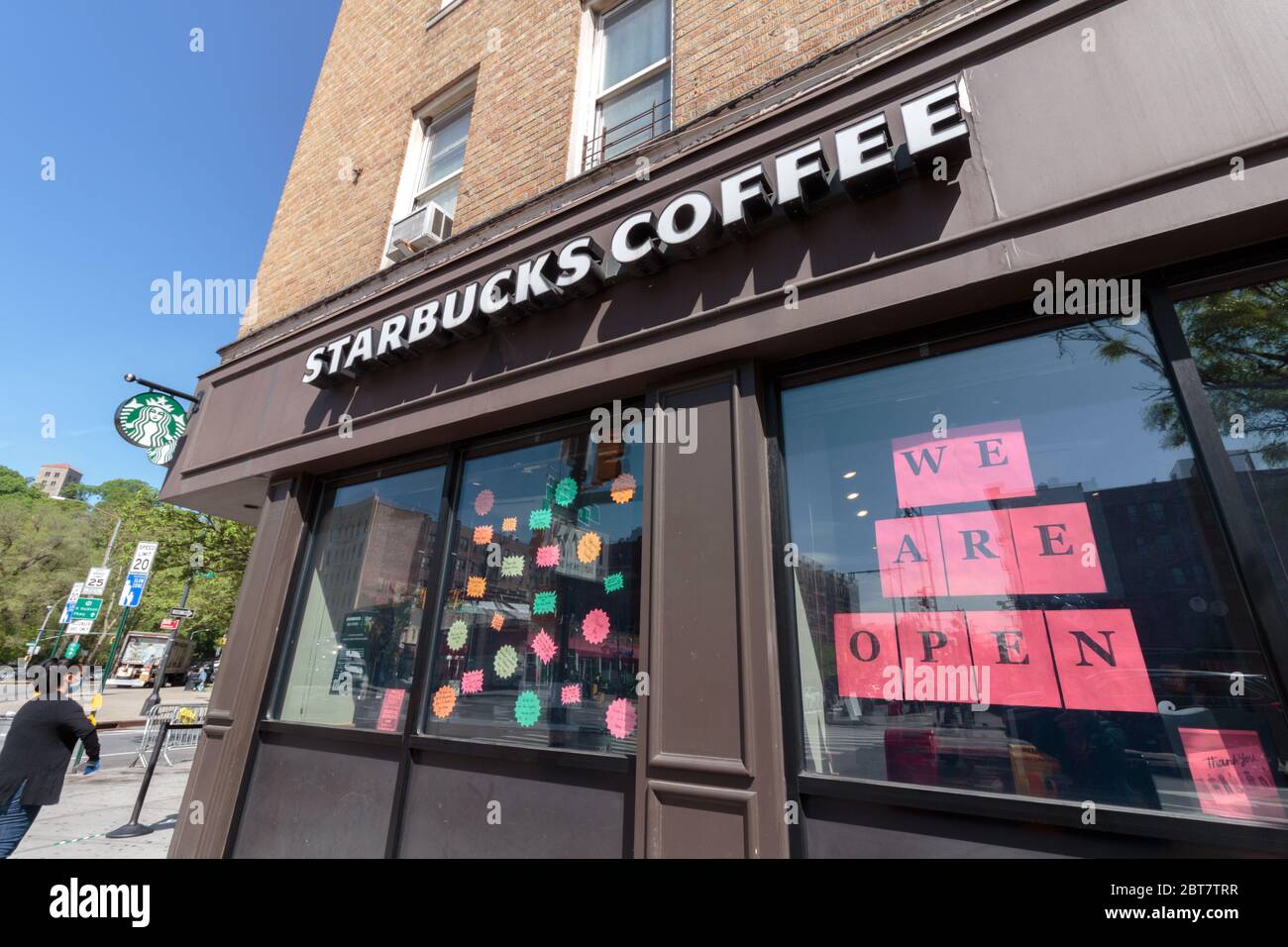We are open sign prominently displayed at the Starbucks Coffee shop on Dyckman St. during the coronavirus or covid-19 pandemic Stock Photo