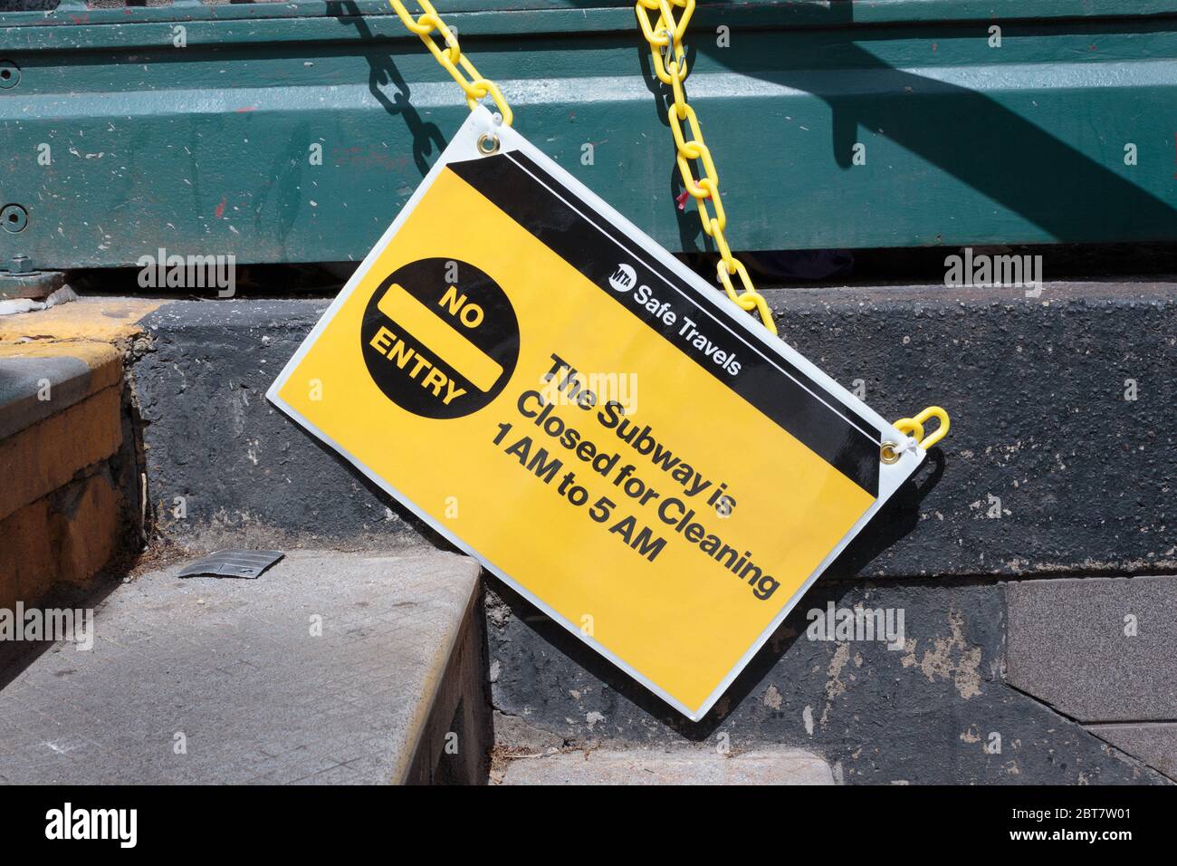 a fallen sign on the stairs of a subway stop says it is closed for cleaning between 1 and 5 am during the coronavirus or covid-19 pandemic Stock Photo
