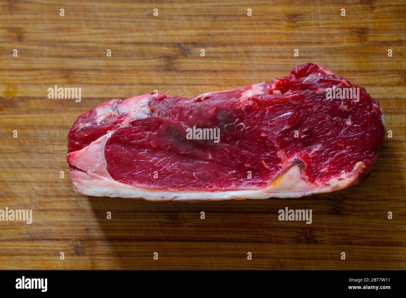 Shots of a sliced raw fresh rump steak with fat on the steak on a wooden  board Stock Photo - Alamy