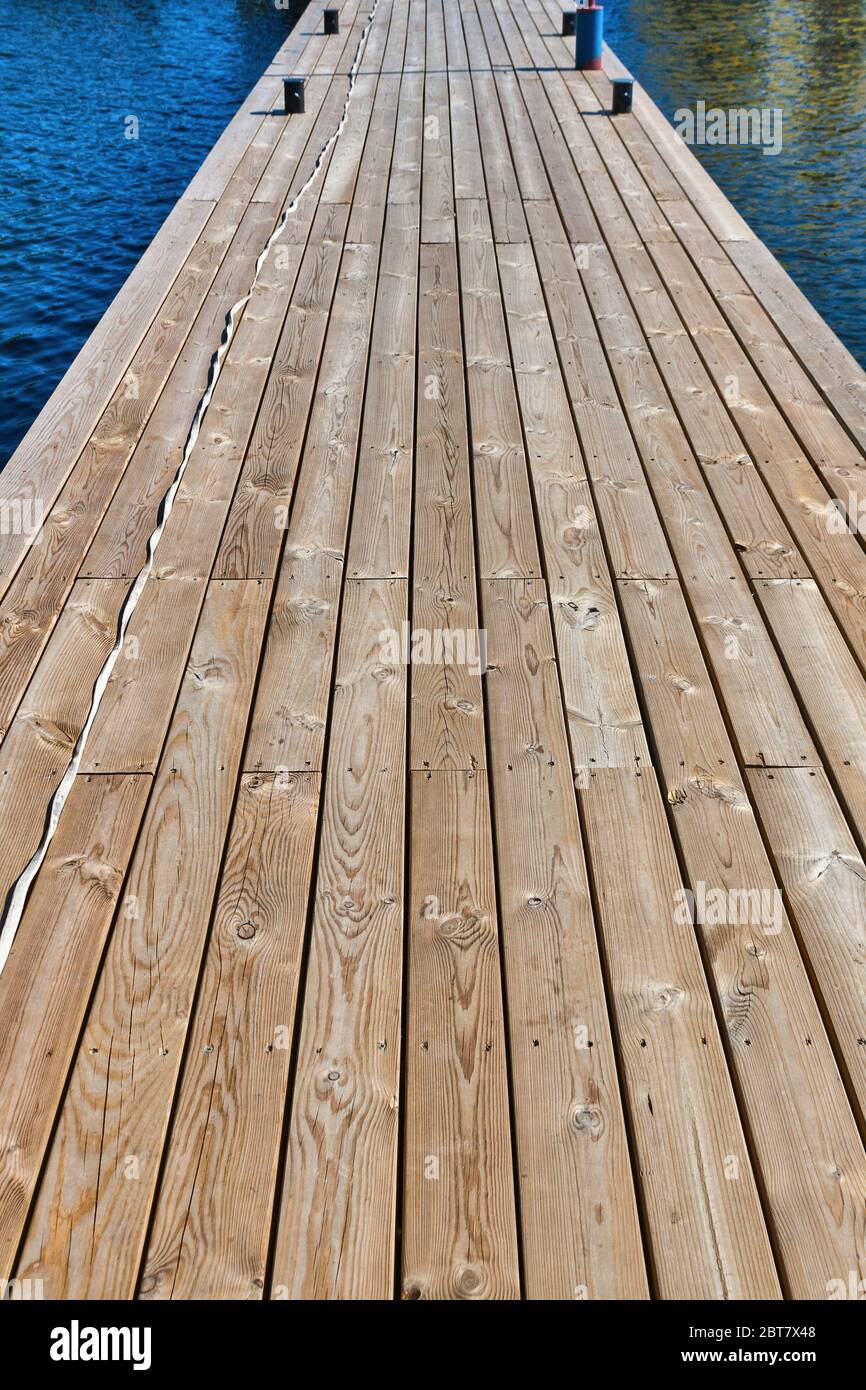 long wooden pier at river closeup mooring posts Stock Photo