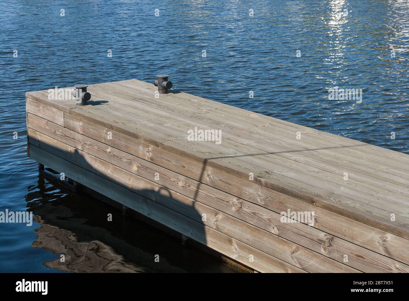 long wooden pier at river closeup mooring posts Stock Photo