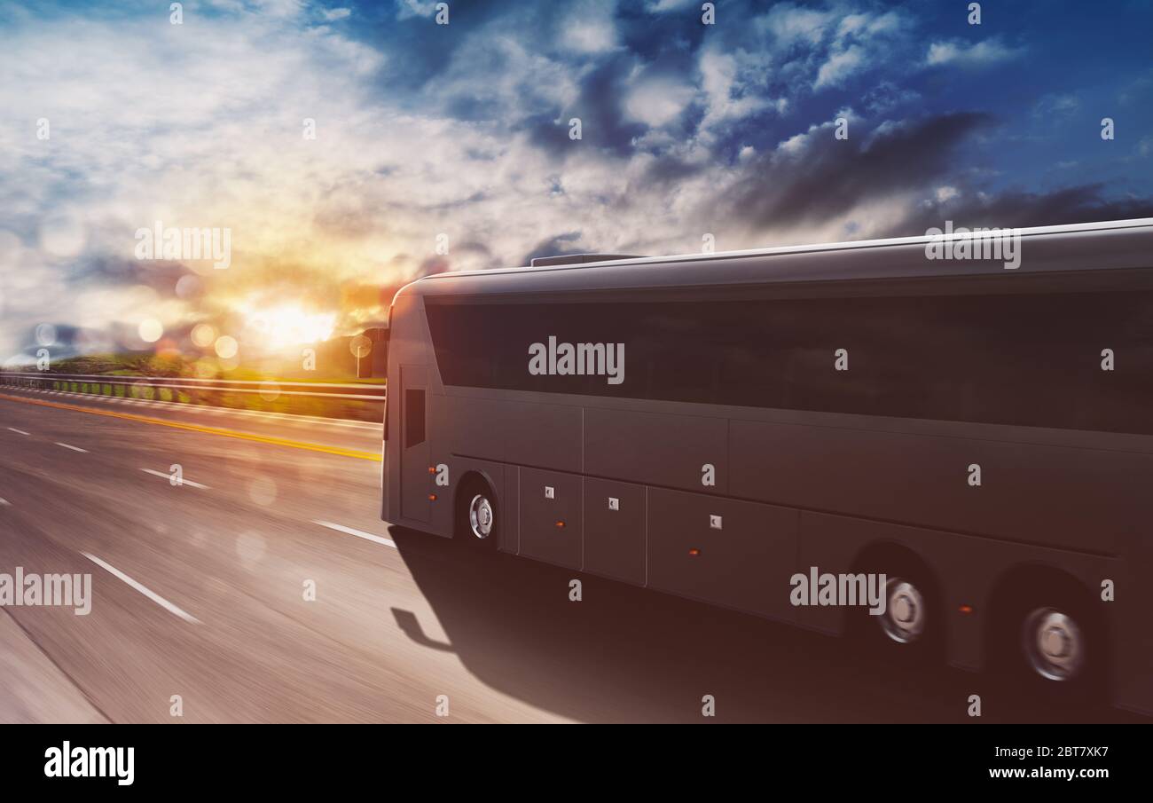 Grand tour bus moving fast on the highway at sunset Stock Photo