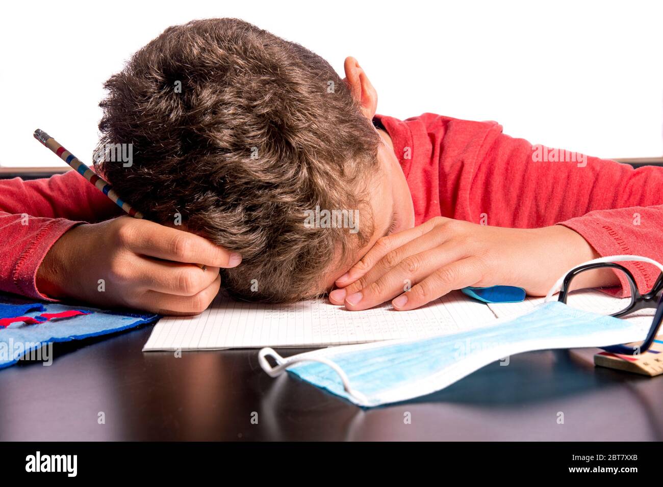 Child collapses over homework in the home office Stock Photo