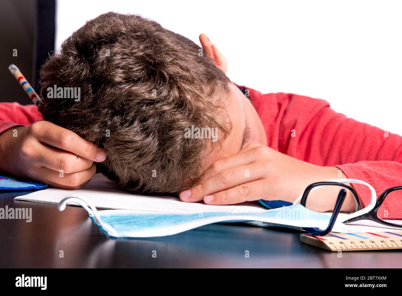 Child collapses over homework in the home office Stock Photo