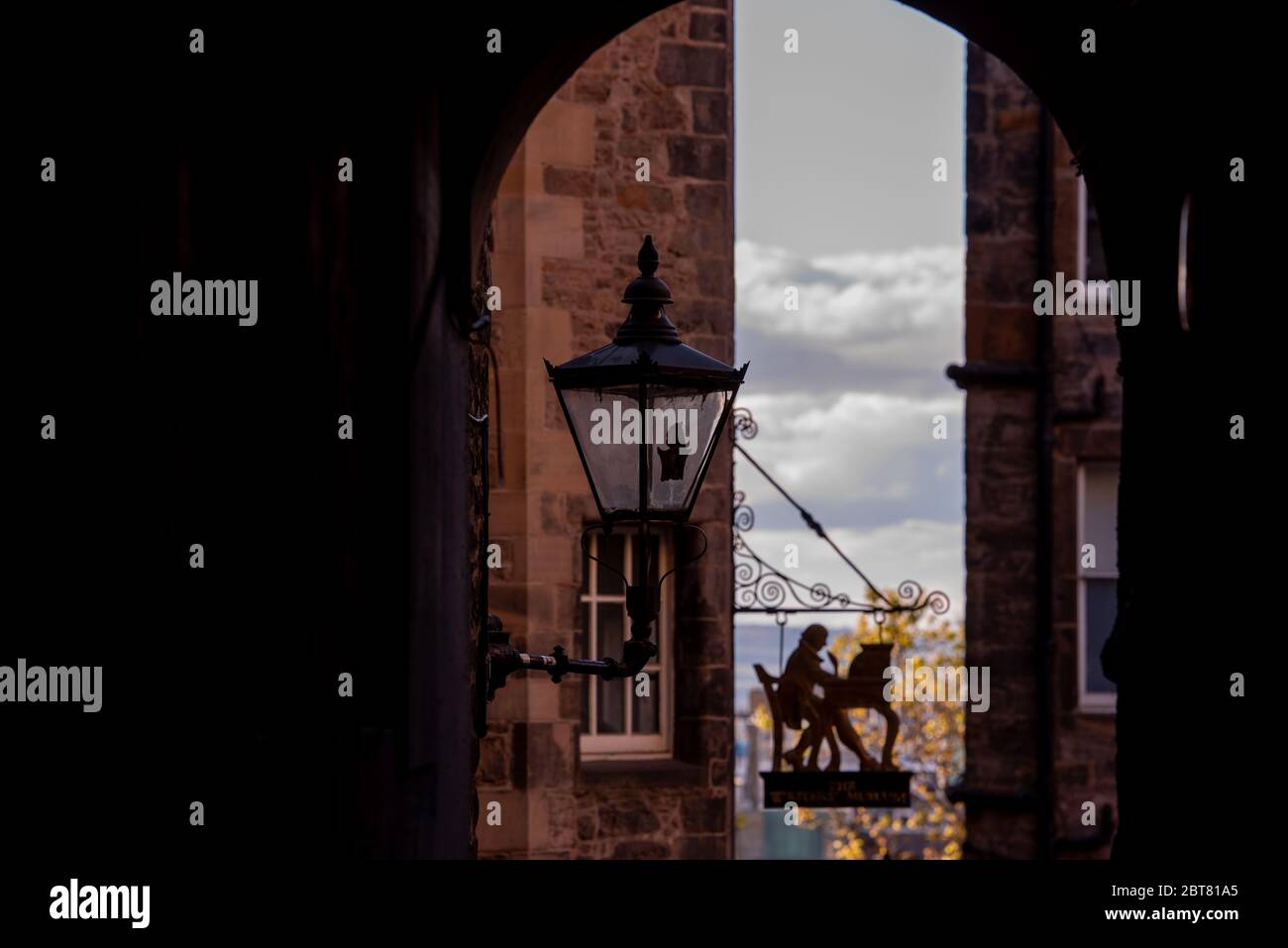 Sign for the Writers Museum Edinburgh through archway with old lantern light Stock Photo