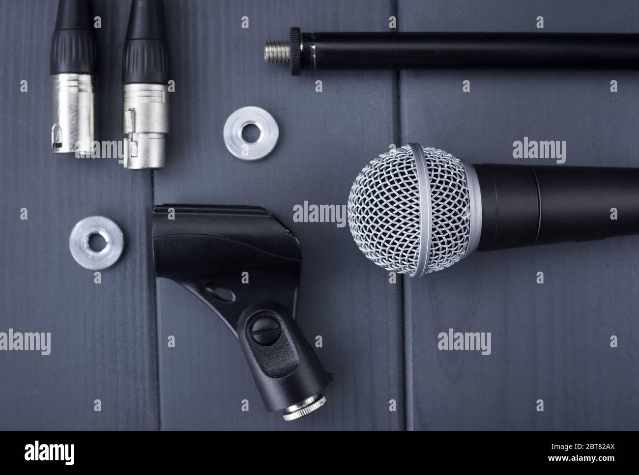 Microphone with stand, lock washers and xlr connectors on wooden table, in complete kit Stock Photo