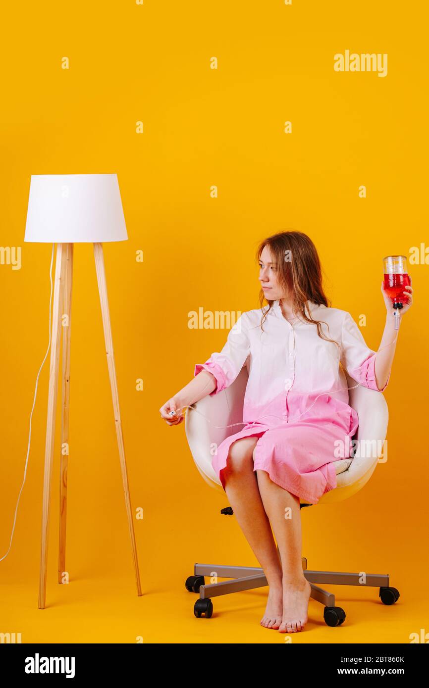 girl sitting on chair with a dropper holding a bottle with medicine in hand Stock Photo