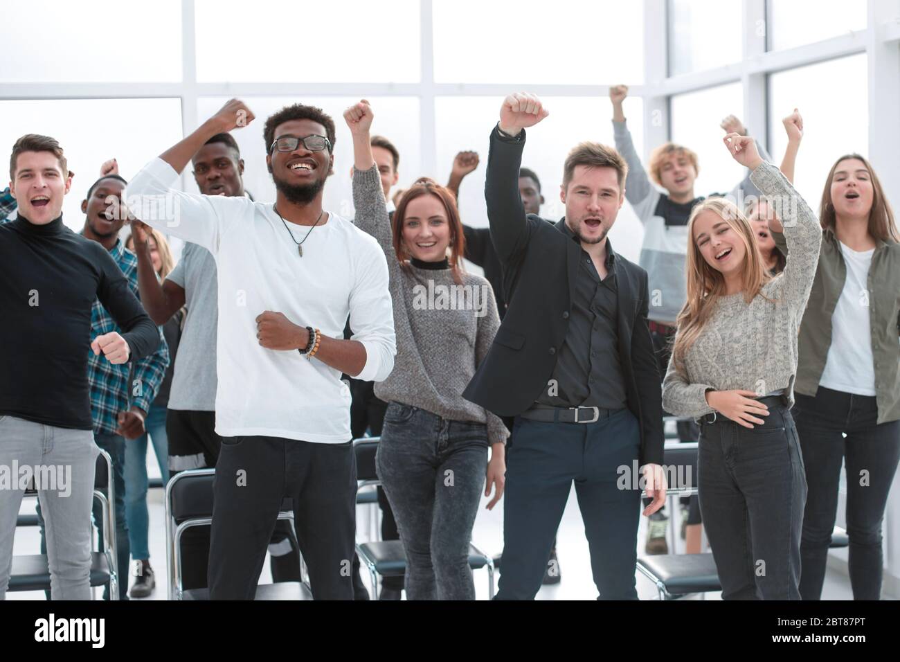 group of happy young people standing with their hands up Stock Photo ...