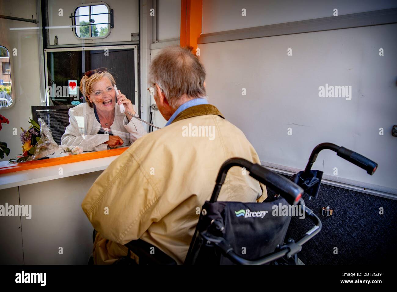 Rijswijk, Netherlands. 23rd May, 2020. Mr. Van Vliet (94 years old) who lives in Laagvoorde (residential care center) speaks to his daughter behind the glass in a horse trailer because the care homes are not yet allowed to receive visitors due to the coronavirus crisis. Credit: SOPA Images Limited/Alamy Live News Stock Photo