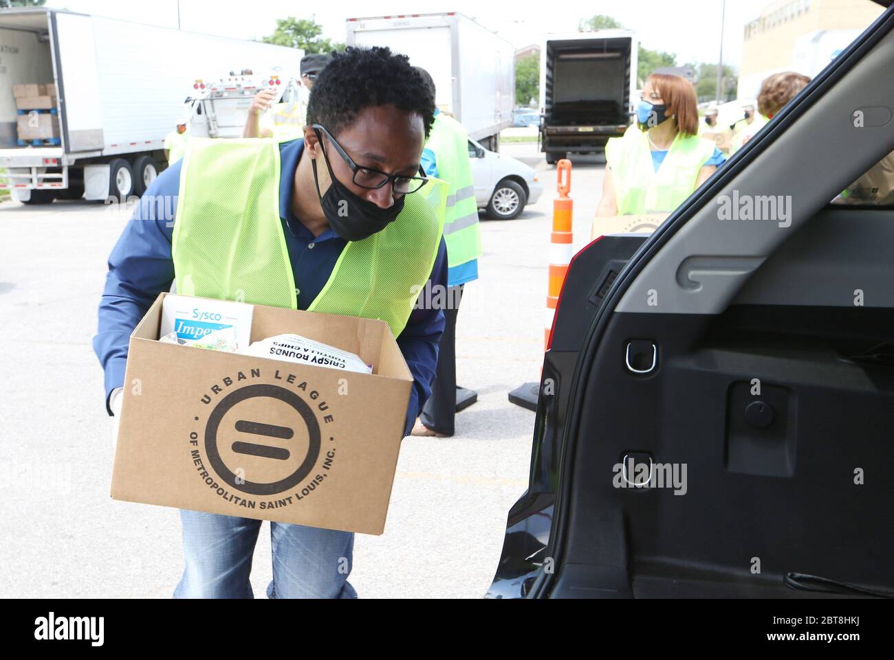 St. Louis, United States. 23rd May, 2020. St. Louis County Prosecuting Attorney Wesley Bell places a box of food into a car at the St. Louis Urban League's food give-a-way in St. Louis on Saturday, May 23, 2020. The 3300 cars that will get food will receive enough food to feed a family of four for several days. This event is the eighth food give-a-way put on by the Urban League. Many are in need of the food due to the coronavirus. Photo by Bill Greenblatt/UPI Credit: UPI/Alamy Live News Stock Photo