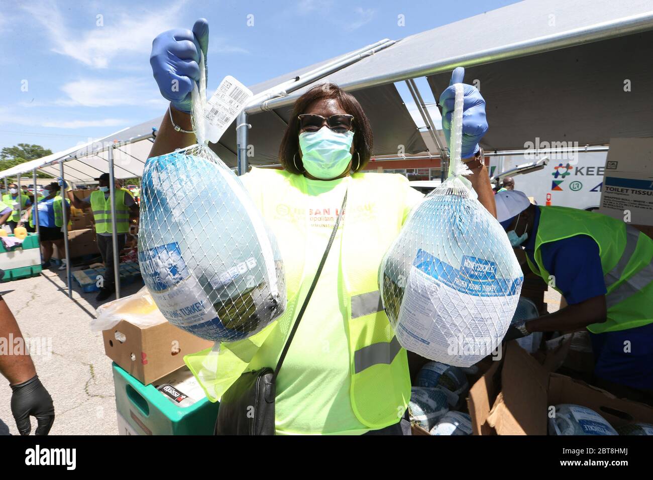 St. Louis, United States. 23rd May, 2020. A volunteer carries frozen turkeys to a waiting car at the St. Louis Urban League's food give-a-way in St. Louis on Saturday, May 23, 2020. The 3300 cars that will get food will receive enough food to feed a family of four for several days. This event is the eighth food give-a-way put on by the Urban League. Many are in need of the food due to the coronavirus. Photo by Bill Greenblatt/UPI Credit: UPI/Alamy Live News Stock Photo