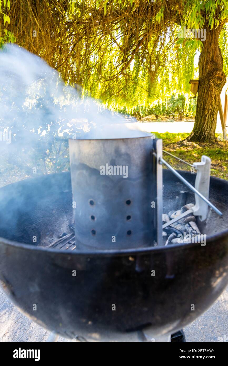Lighting a barbecue with a chimney starter Stock Photo Alamy