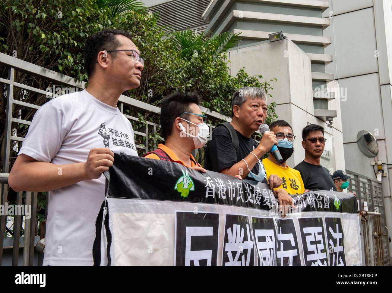 May 24, 2020, Hong Kong, Hong Kong, China: With this years June 4th event banned, people participate in a 10km run to commemorate the 31st anniversary of the 1989 Democratic Movement in China that ended with the Tiananmen Square incident. The run takes in sites of importance to the fight for democracy in Hong Kong.LEE CHEUK-YAN (c), former legislator and one of the arrested "Democracy 15"", speaks outside the Liaison Office of the Central People's Government in Hong Kong SAR, Sai Yin Pun. Fellow "Democracy 15"" arrestee, Richard Tsoi joins him (Credit Image: © Jayne Russell/ZUMA Wire) Stock Photo