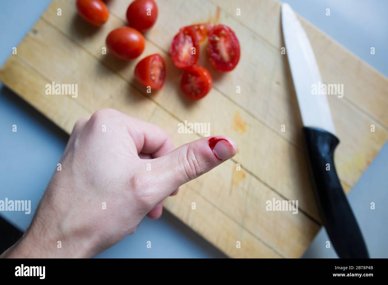 Young man finger cut while cooking a lunch, bleeding, cooking injury