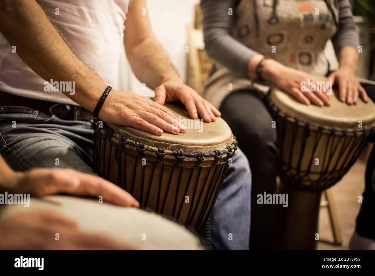 Close up of hands on african drums, drumming for a music therapy
