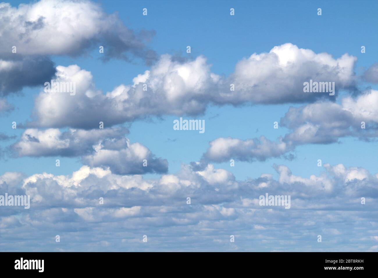 White fluffy clouds on a background of blue sky in summer. The concept of weather and climate. Stock Photo