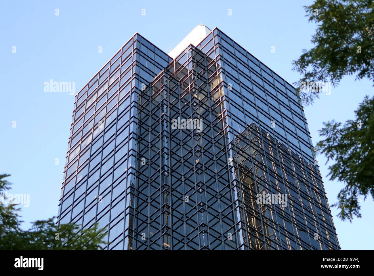 Motion of blue sky with illuminated reflected glass facade on modern office building Stock Photo