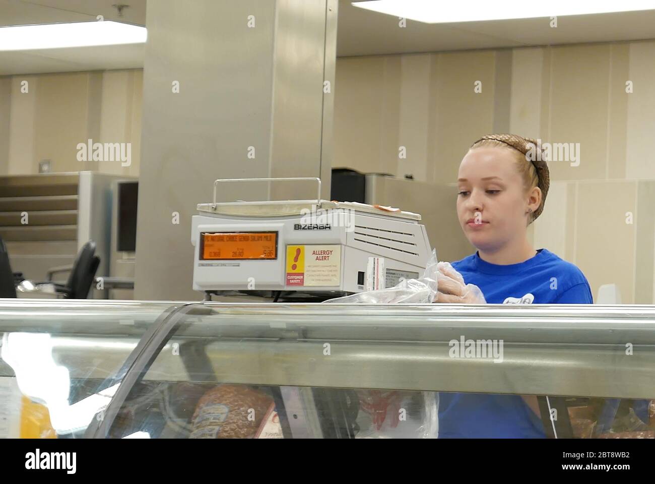 Motion of friendly clerk weight the meat for customer inside superstore Stock Photo