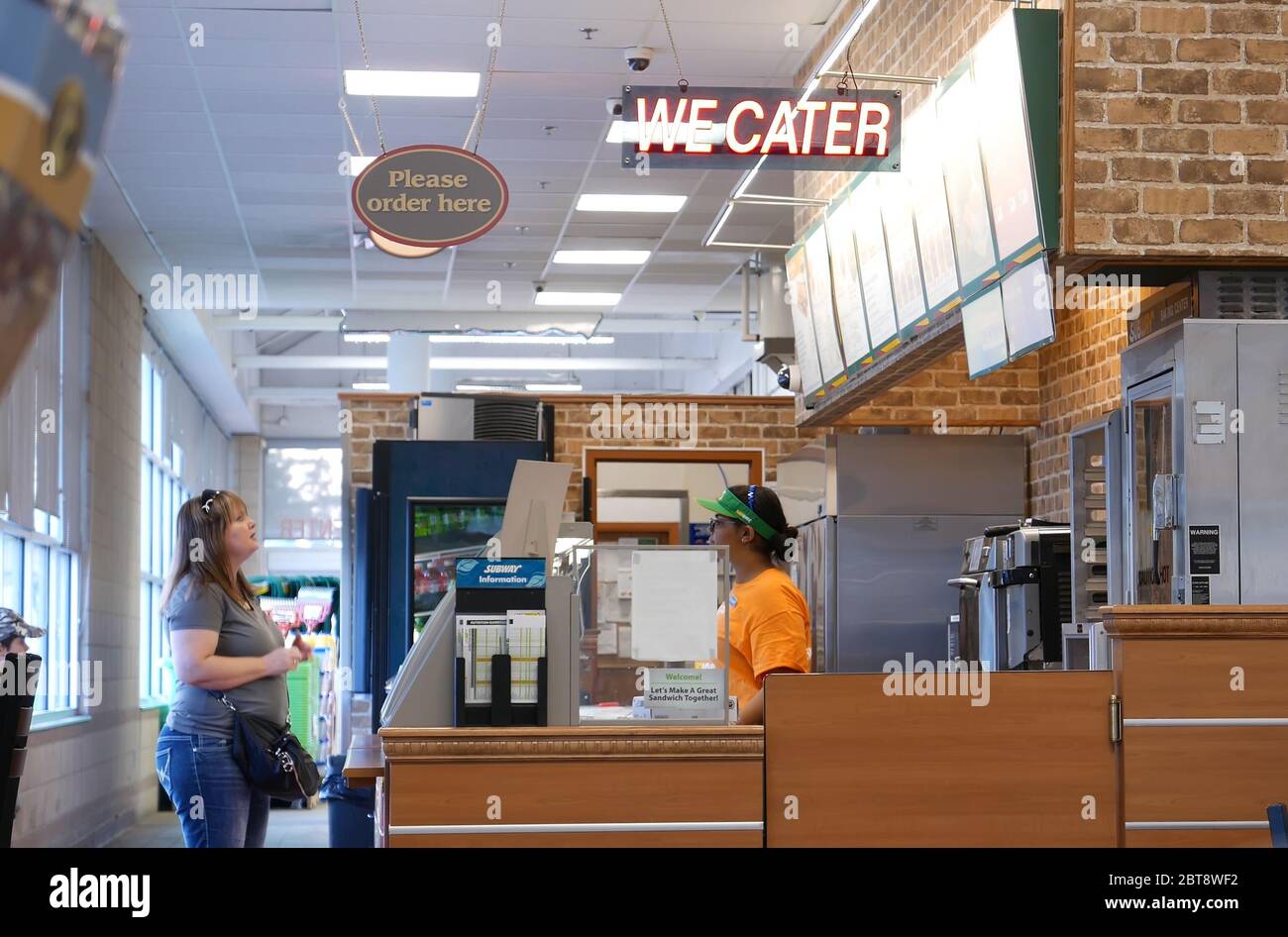 Motion of worker preparing sandwich for customer inside subway restaurant Stock Photo