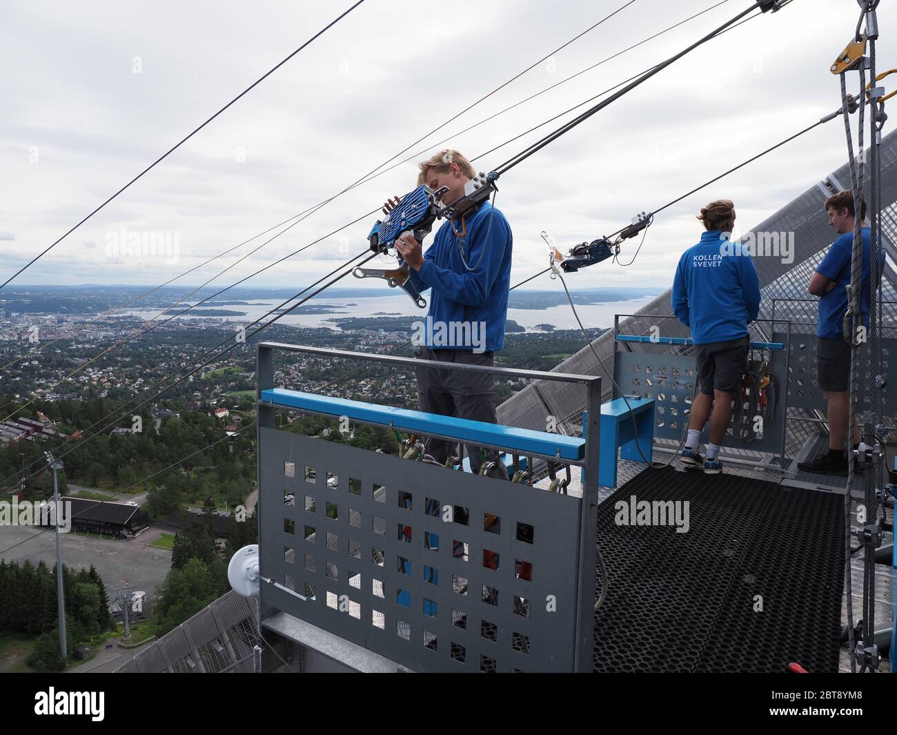 Oslo Norway On July 19 Three Young Men Care About Zipline Rider In European City Seen From Ski Jump In Holmenkollen District Cloudy Sky In Cold S Stock Photo Alamy