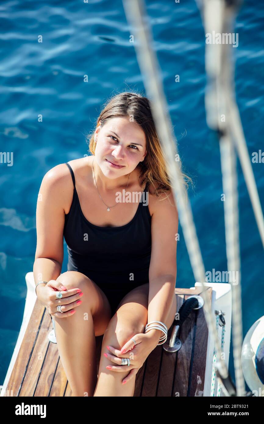 Pretty young woman relaxing on the yacht on sea at sunny day Stock Photo