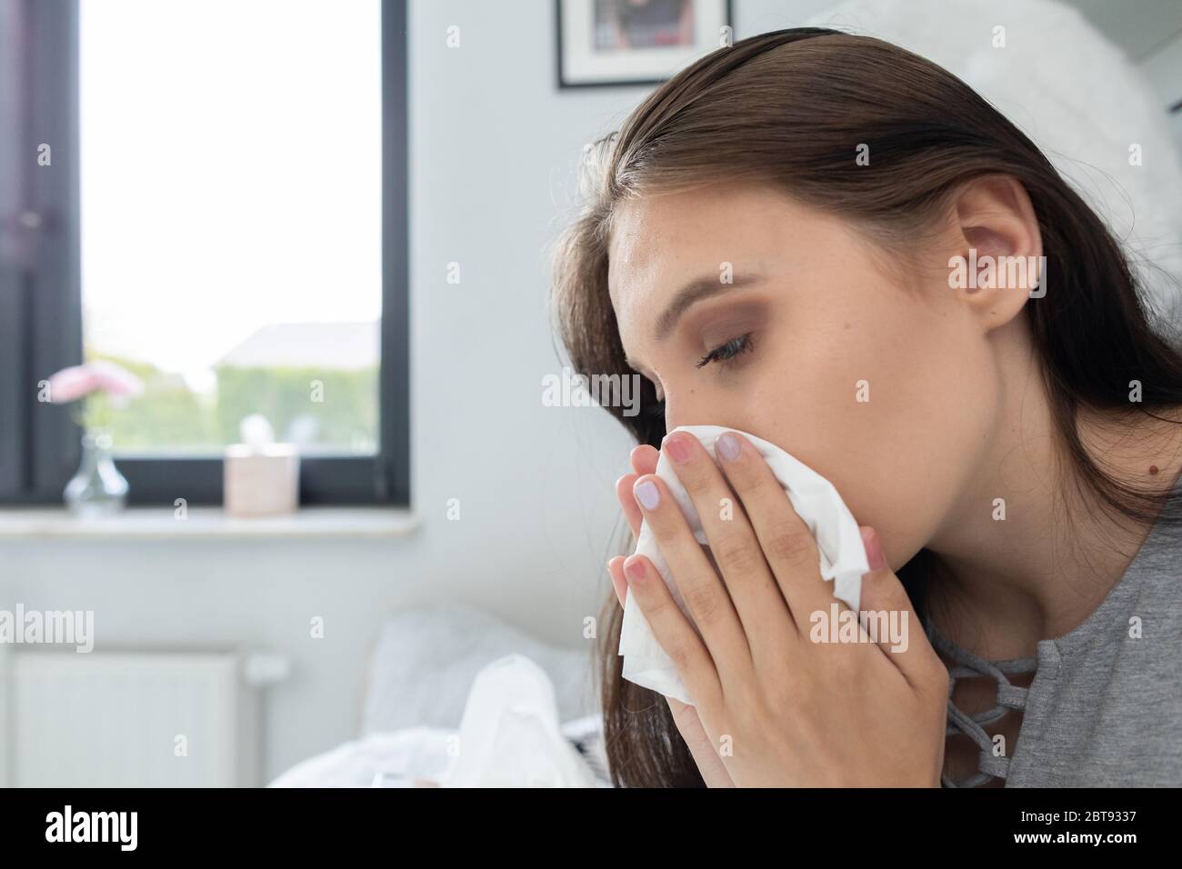 A severe cold causing a headache and the need to constantly wipe the