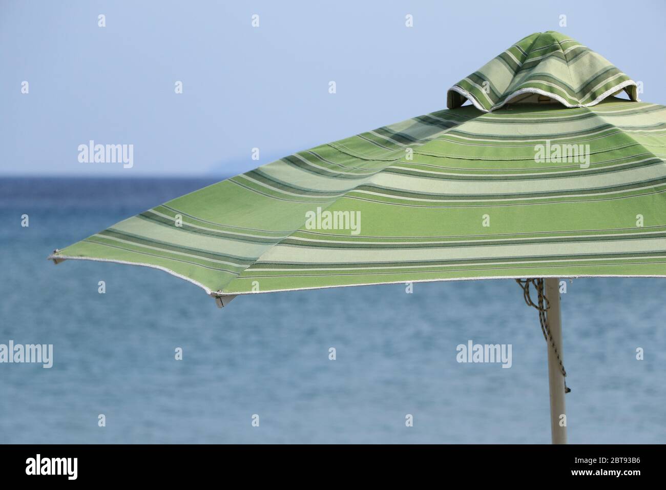 Green and white striped beach umbrella Stock Photo - Alamy