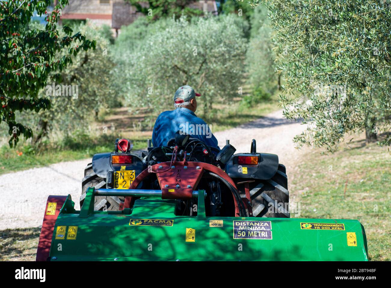 terni, italy may 24 2020:tractor and stalk chopper ready for chopping in the sun Stock Photo