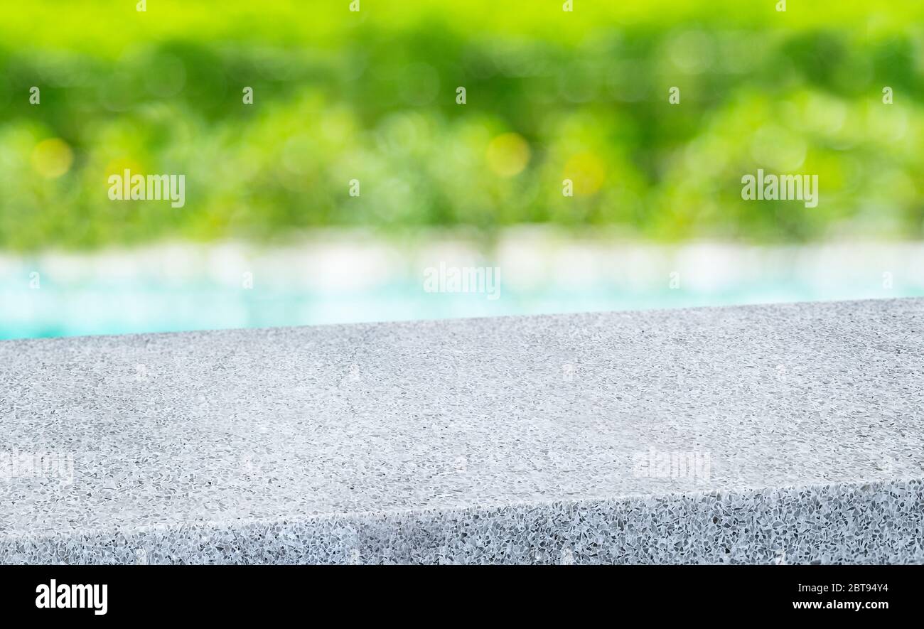 spring background.Empty diagonal pebble grey stone table with blur tree and pond in garden boekh background,banner mockup template for display of prod Stock Photo