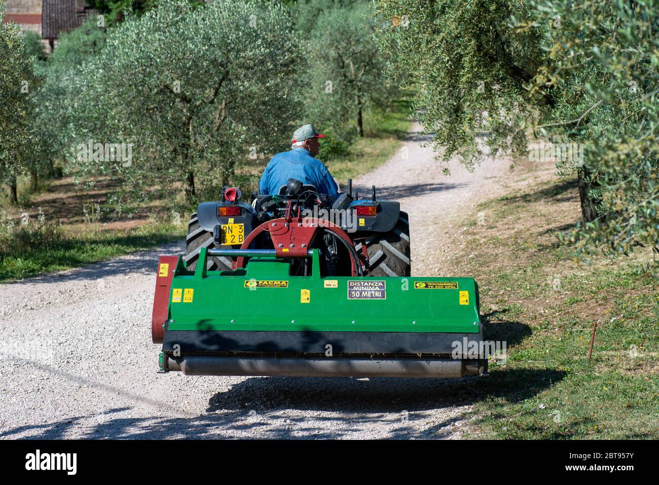 terni, italy may 24 2020:tractor and stalk chopper ready for chopping in the sun Stock Photo