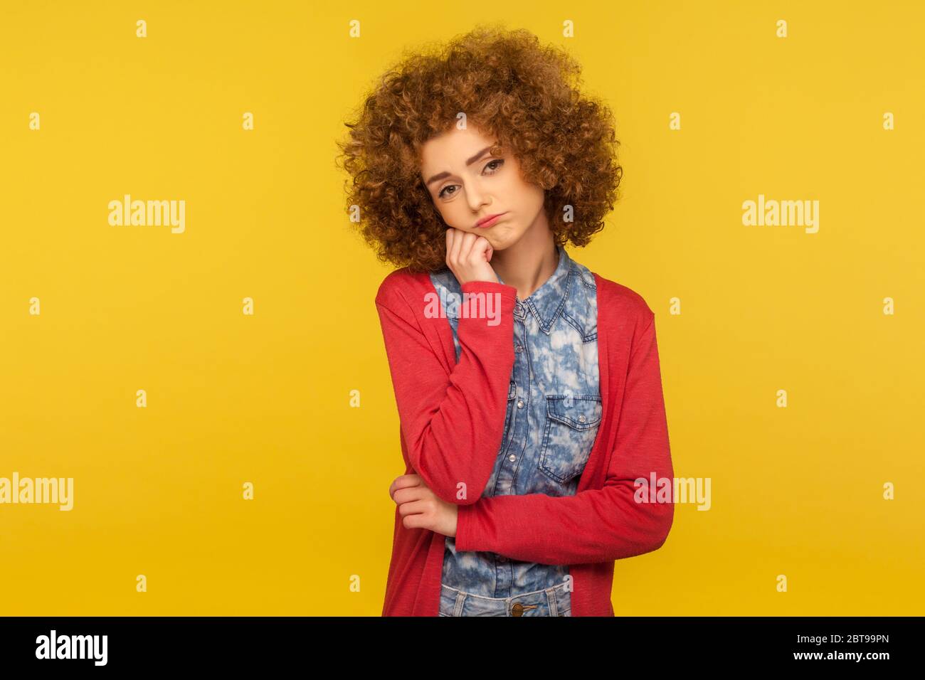 Bored tired lazy woman with curly hair leaning on hand and looking at camera with apathetic indifferent expression, listening boring conversation. ind Stock Photo