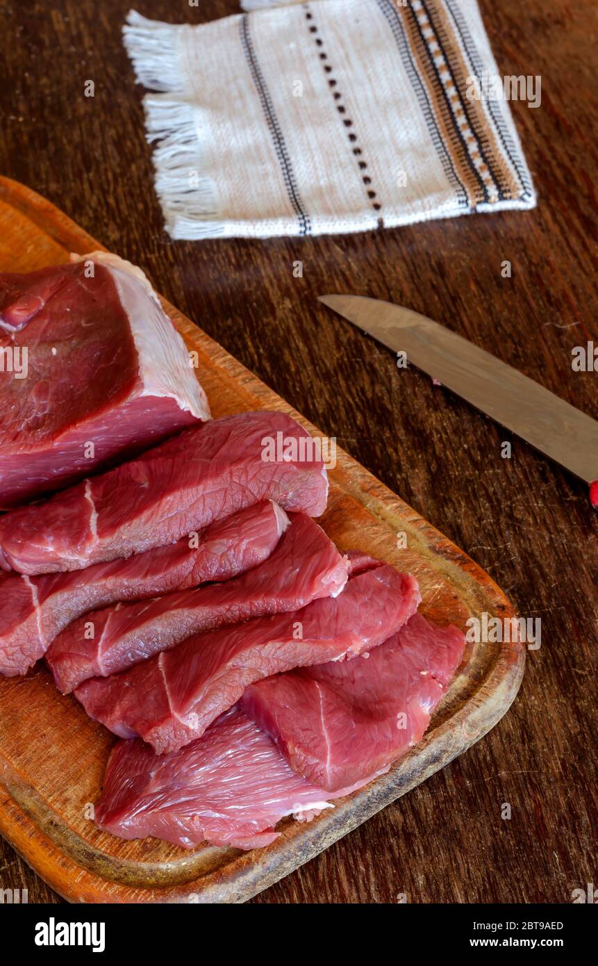 Portioned slices of raw meat on a cutting board. Fresh pieces of chopped  beef tenderloin close-up. Five juicy slices of beef. Ingredients for  preparin Stock Photo - Alamy