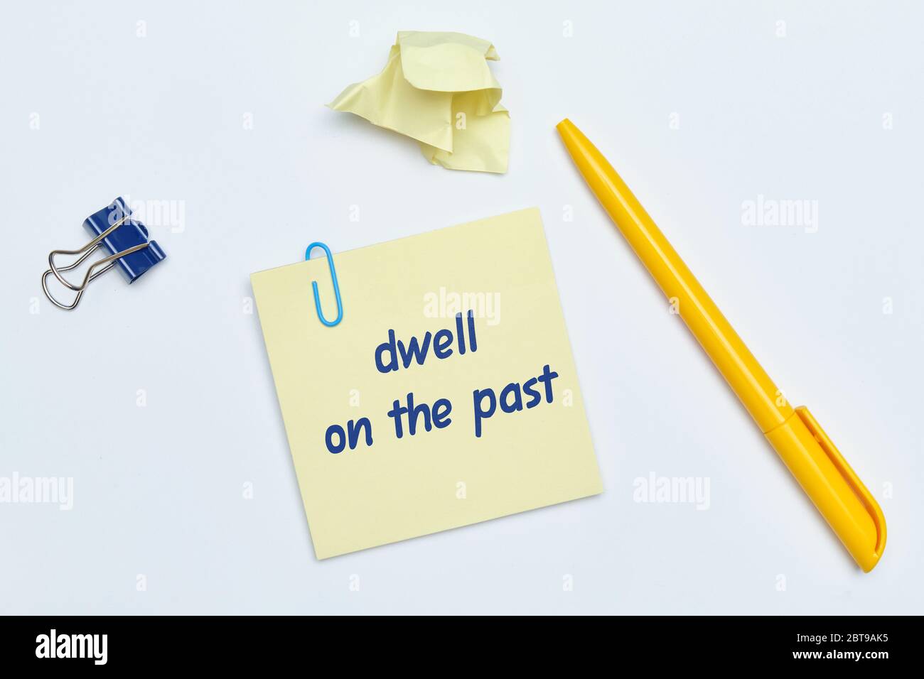 English idiom hand lettering about time - dwell on the past on wooden blocks. Close up. Stock Photo
