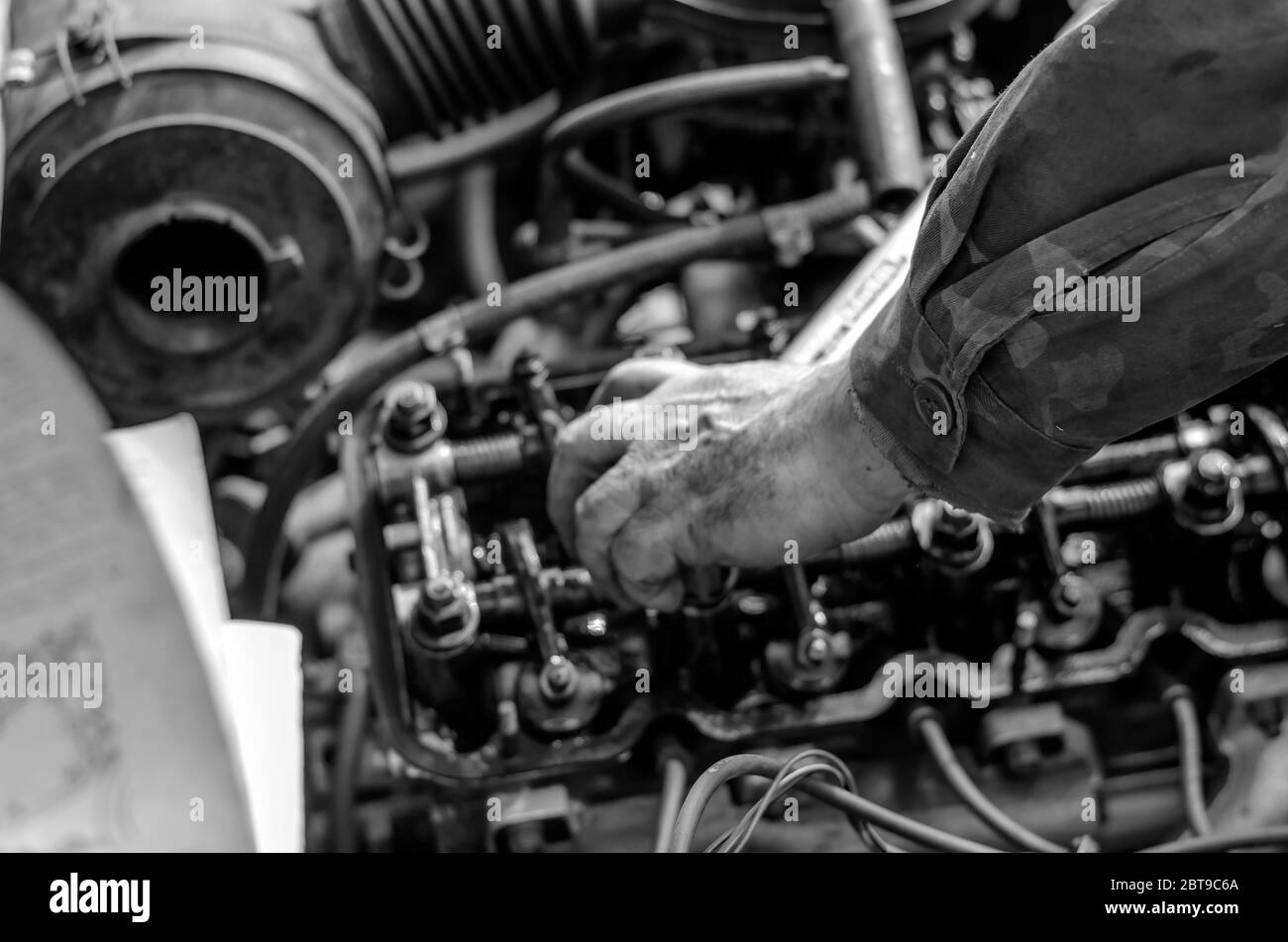 The engine compartment of a passenger car closeup. Tightening the cylinder head. Manual