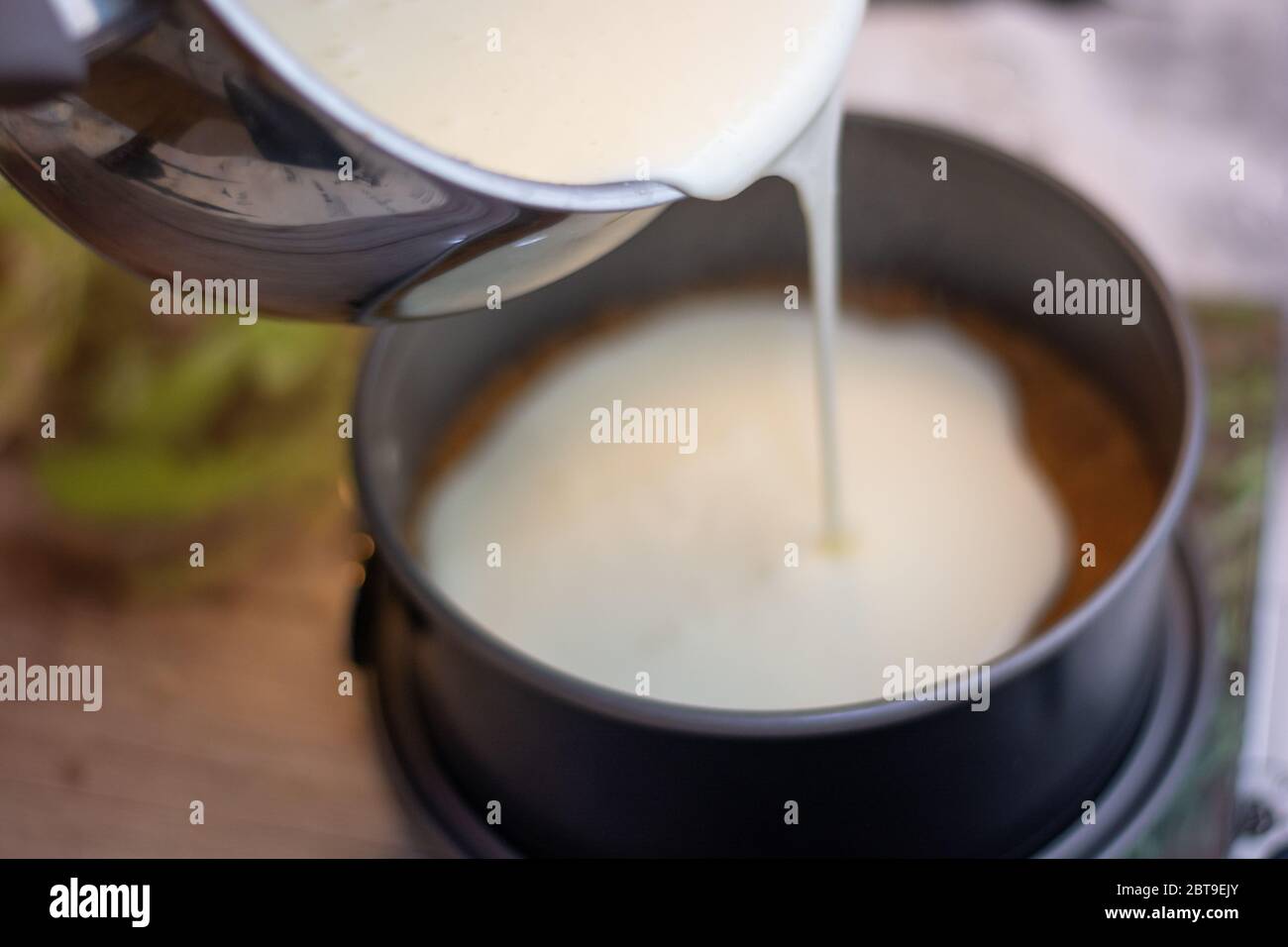 Making a new York cheesecake or classic cheesecake: add the cheese cream on the cookie base Stock Photo