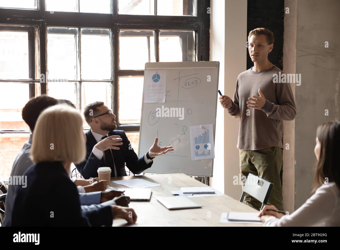 Business coach answering employee question about project at corporate meeting Stock Photo