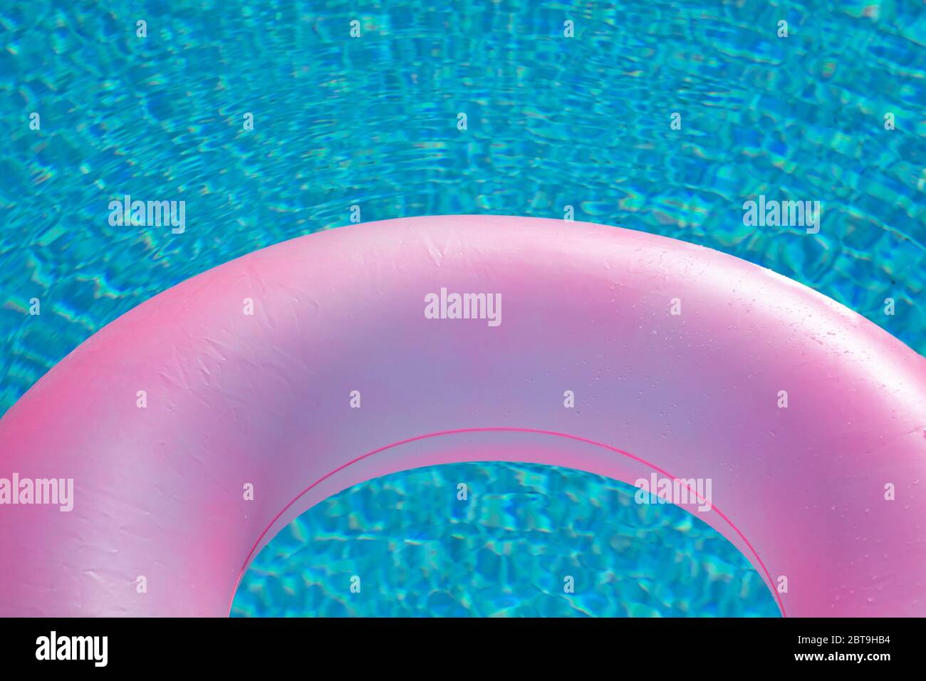 Pink big float on pool with a blue water ready to swim Stock Photo - Alamy