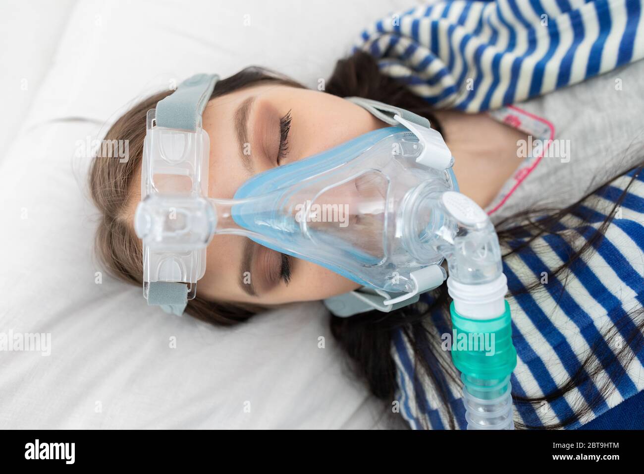Oxygen mask attached to the respiratory tract. The teenager lies in a