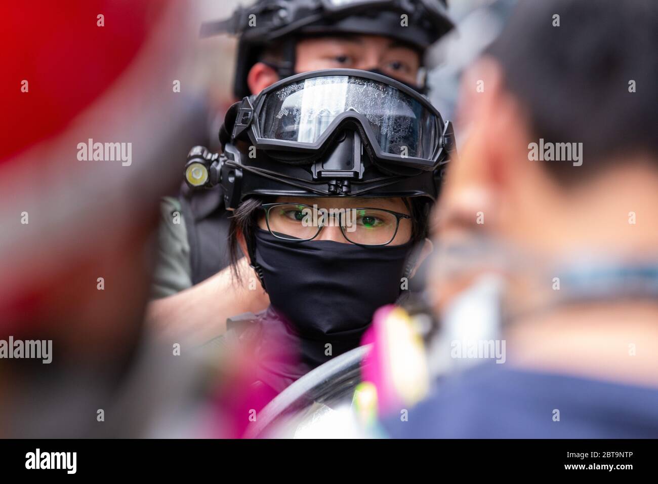 Hong Kong, 24th May 2020. Female HK Police Officer watching the crowd..Credit: David Ogg / Alamy Live News Stock Photo