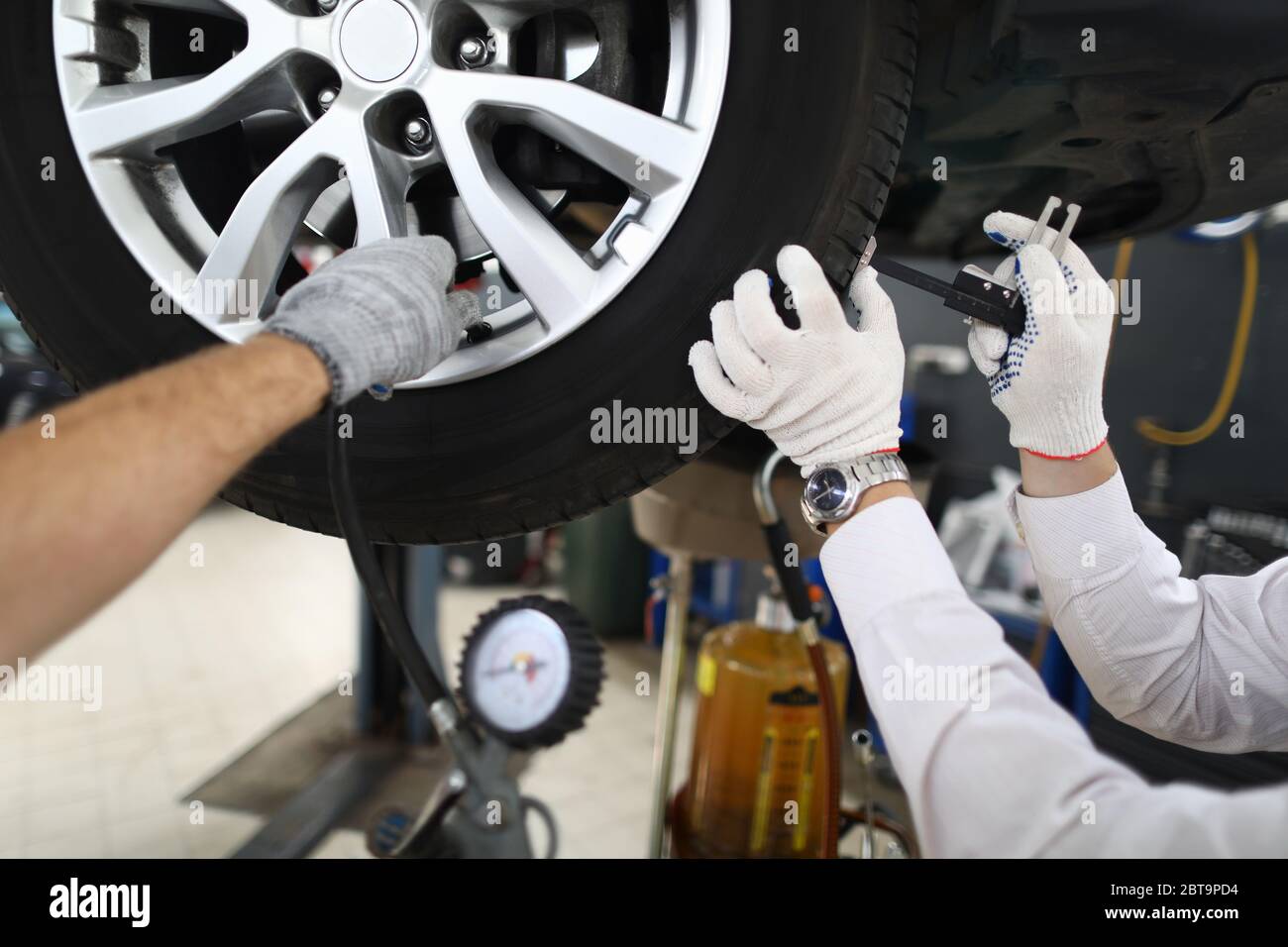 Mechanic repairing wheels, seasonal tire change Stock Photo Alamy