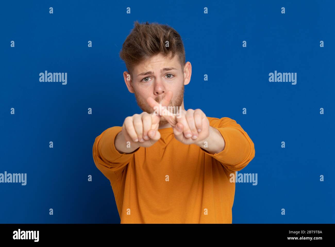 Attractive young guy with a yellow T-shirt on a blue background Stock ...