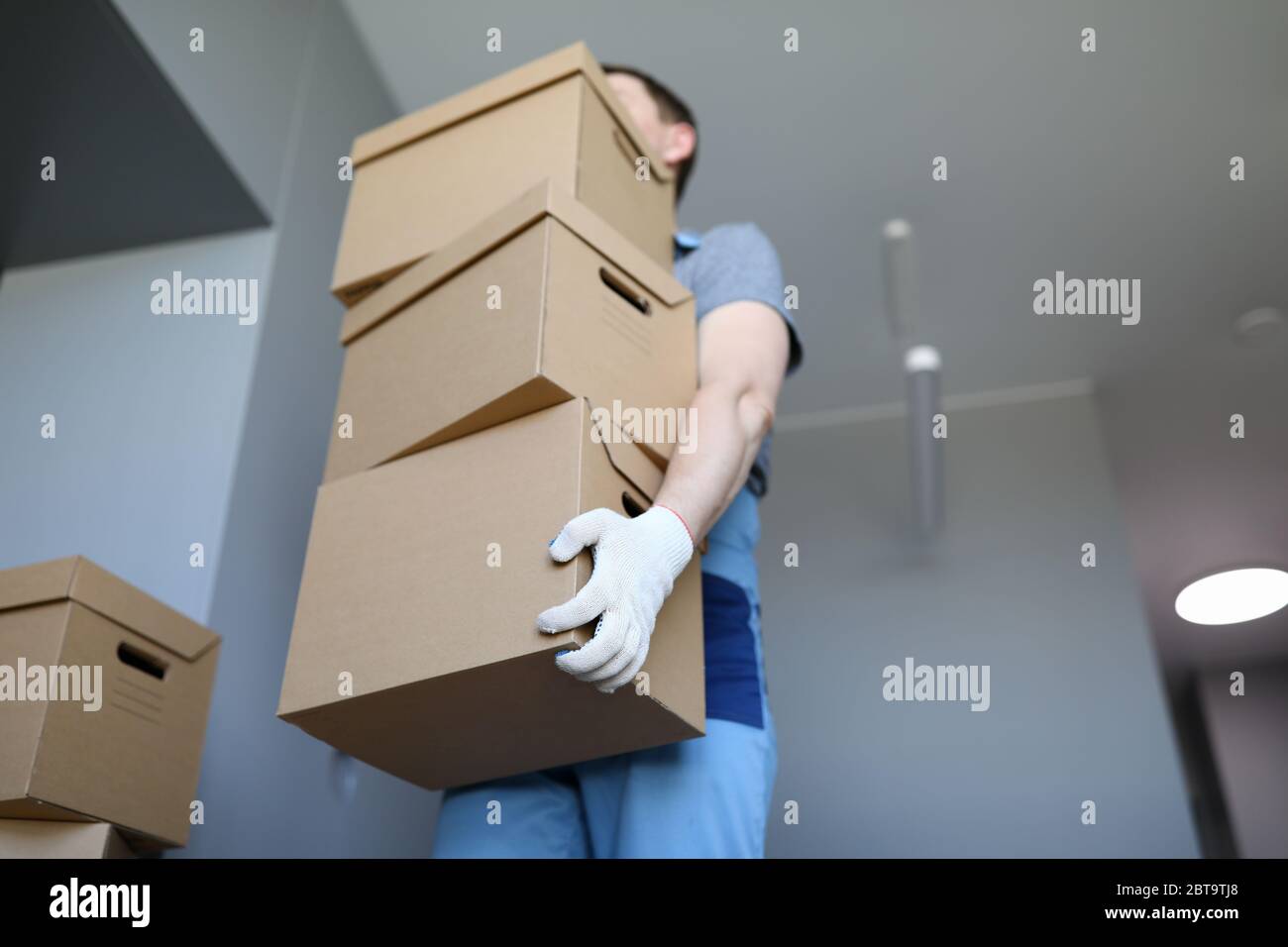 Man work clothes and gloves carries cardboard boxes Stock Photo Alamy