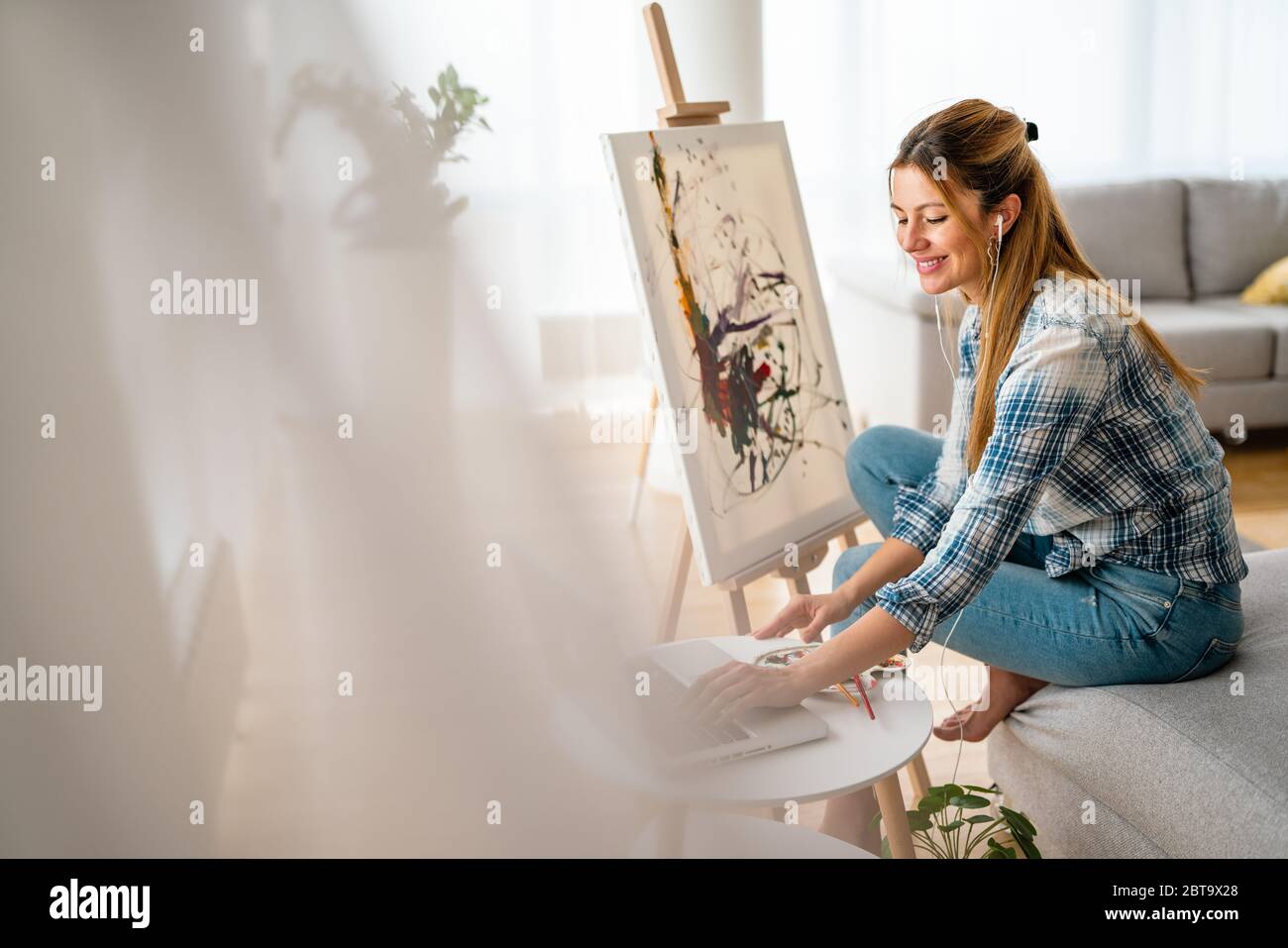 Art, creativity, hobby, job and creative occupation concept. Woman painting at home. Stock Photo