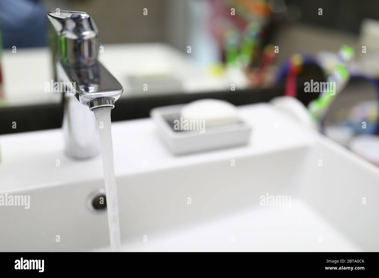 Stream water flows from faucet into bathroom sink Stock Photo Alamy