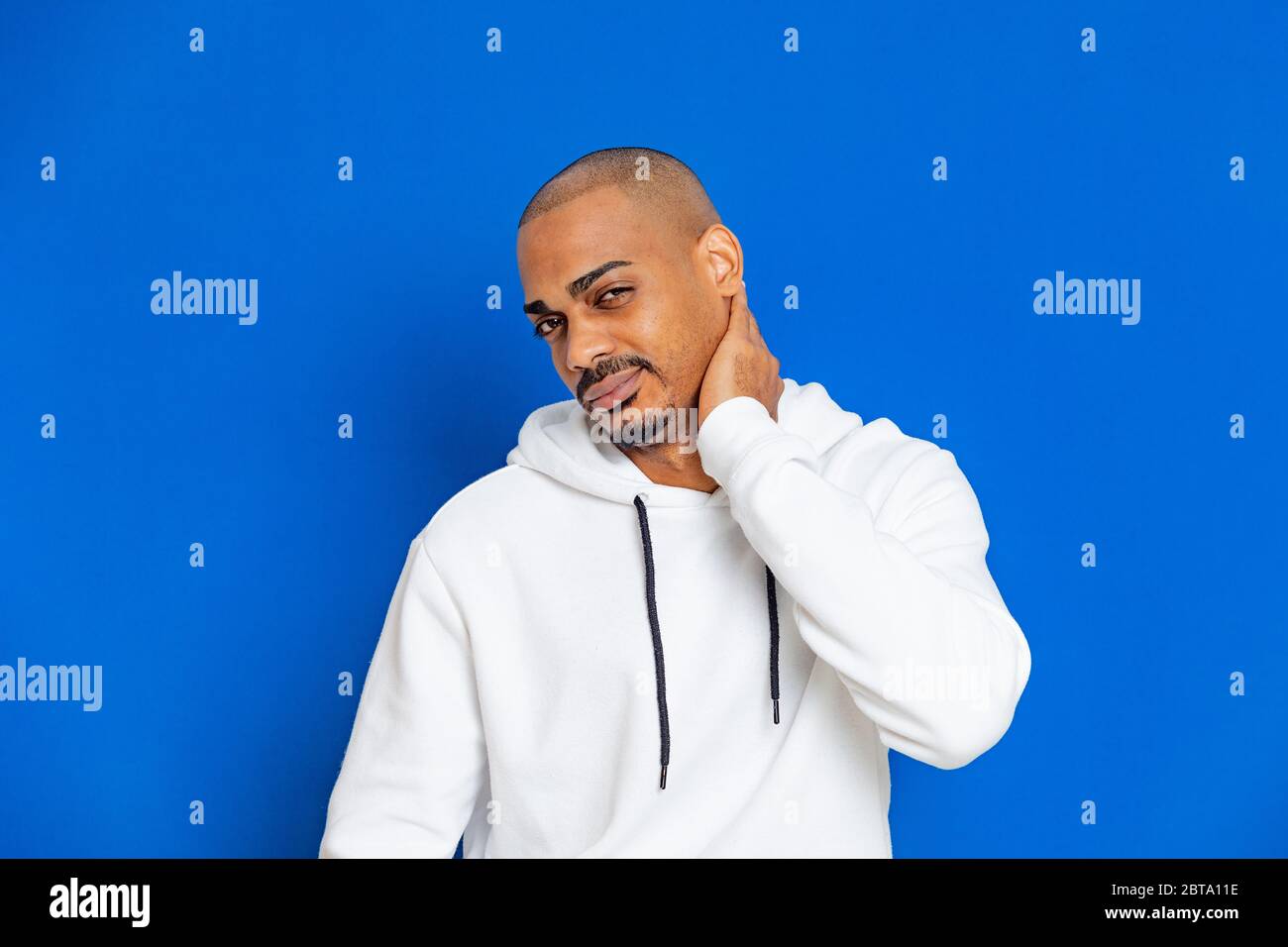 African guy wearing a white sweatshirt on a blue background Stock Photo