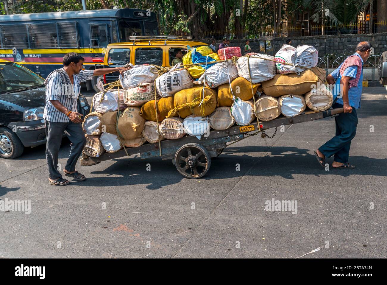 To young Indian push a cart with in Mumbai Stock Photo