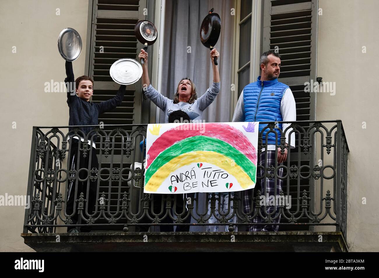 Turin, Italy - 13 March, 2020: A family play lids of pots and pans from balcony of their home where there is a banner reading 'Everything will be fine' in the neighborhood San Salvario during a flash mob launched throughout Italy to bring people together. The Italian government imposed unprecedented restrictions to halt the spread of COVID-19 coronavirus outbreak, among other measures people movements are allowed only for work, for buying essential goods and for health reasons. Credit: Nicolò Campo/Alamy Live News Stock Photo
