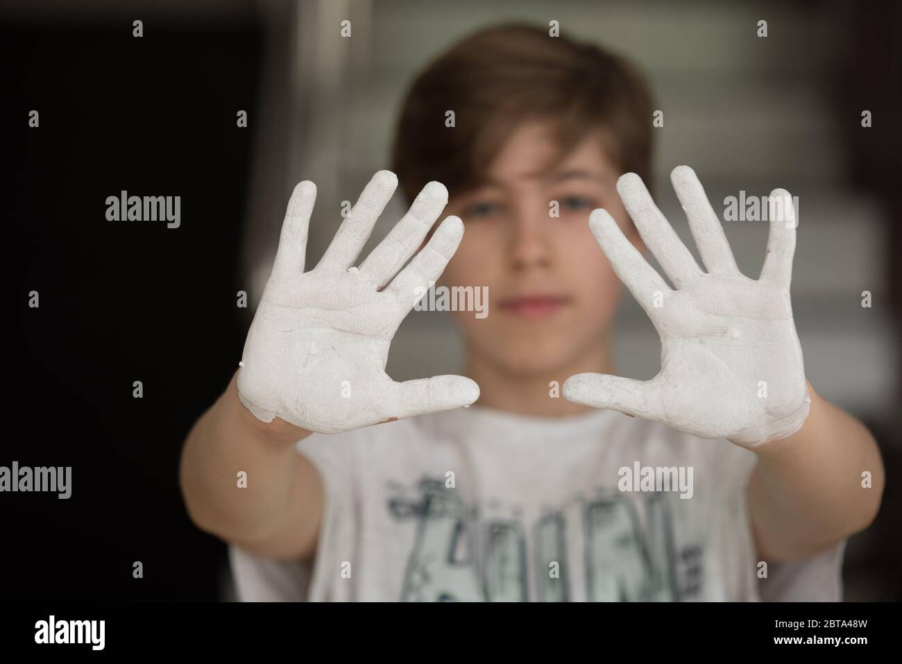 Young boy showing his hands painted with white paint Stock Photo Alamy